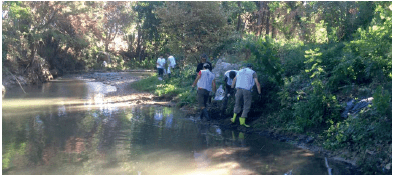 Sur la photo, on voit un groupe de personne en train de ramasser les macro-déchets présent sur les berges de l’Huveaune et dans le lit du cours d’eau.