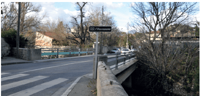Texte de remplacement : La photo montre un panneau indiquant « Huveaune » à l’extrémité d’un pont franchissant le cours d’eau. Jusqu’en 2014 il n’y avait aucun panneau indiquant la présence de l’Huveaune (excepté à Saint-Zacharie)